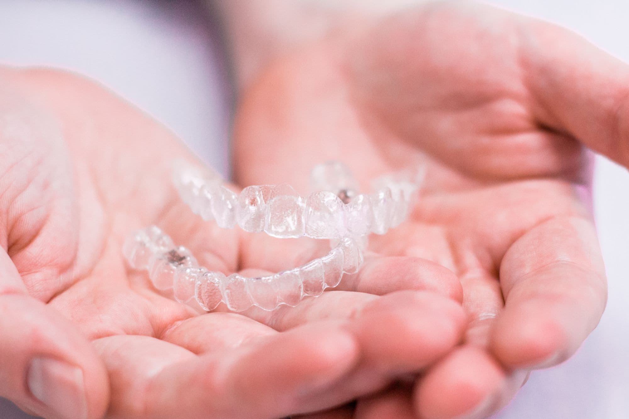 hands holding aligners
