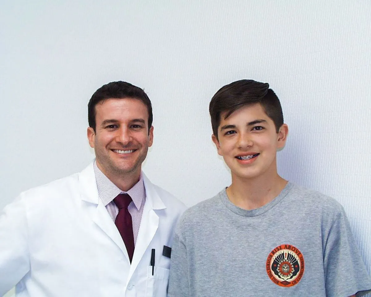 Orthodontist with a smiling teen boy