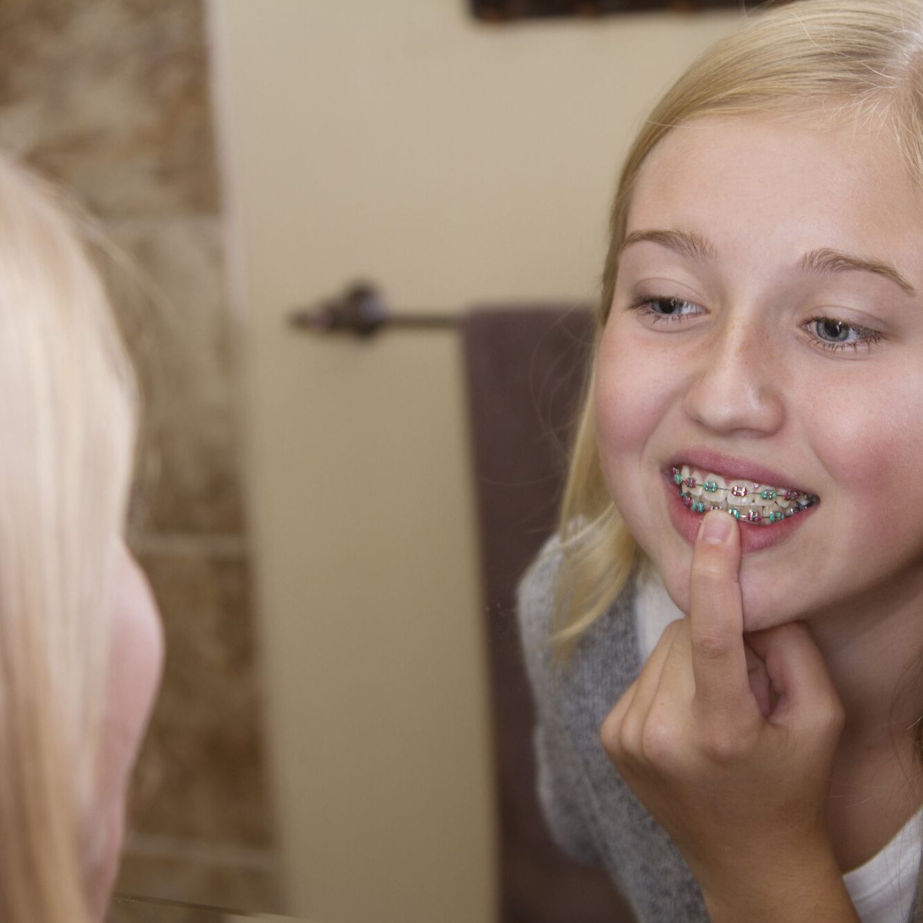 Girl with braces looking in mirror